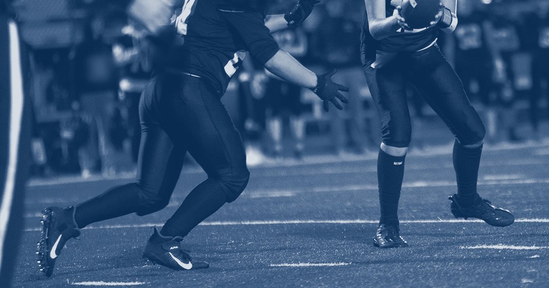 High school football players on the field under the lights